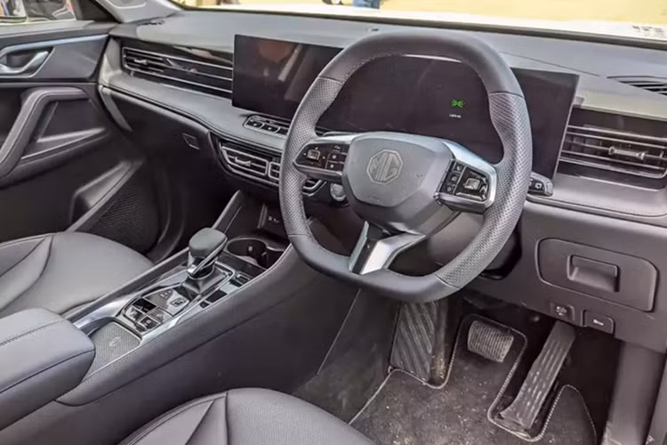 Sâu xuống phía dưới là đèn phản quang 3 tầng, 2 đầu ống xả giả mạ crôm và bộ khuếch tán gió dưới cản sau. Ở bên trong, MG HS 2025 được trang bị 2 màn hình 12,3 inch nối liền với nhau trên mặt táp-lô và cần số mới ở cụm điều khiển trung tâm.