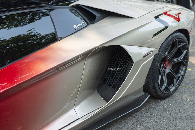 Nhìn ngang hông xe, có thể thấy ốp hốc gió bên sườn được làm lớn và góc cạnh hơn. Đi kèm với đó là líp sườn bằng sợi carbon. Ốp gương chiếu hậu cũng được độ loại làm từ vật liệu carbon, có điểm nhấn bằng đường viền màu bạc cùng dòng chữ “Aventador”.