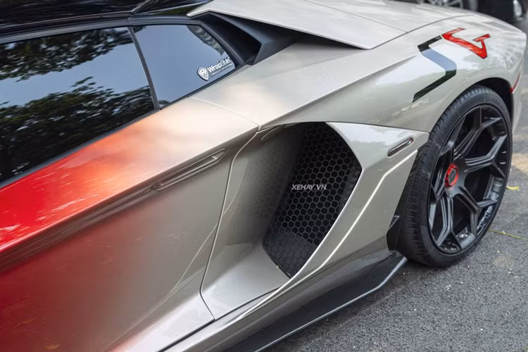 Nhìn ngang hông xe, có thể thấy ốp hốc gió bên sườn được làm lớn và góc cạnh hơn. Đi kèm với đó là líp sườn bằng sợi carbon. Ốp gương chiếu hậu cũng được độ loại làm từ vật liệu carbon, có điểm nhấn bằng đường viền màu bạc cùng dòng chữ “Aventador”.