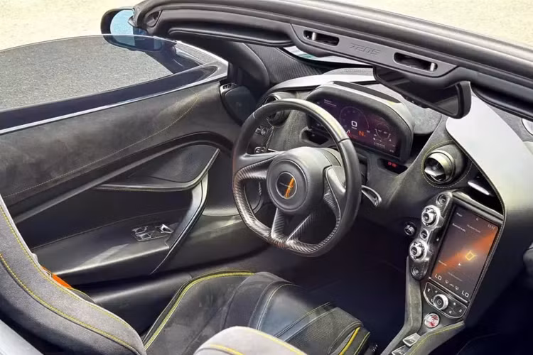 Bên trong khoang lái chiếc siêu xe mui trần McLaren 720S Spider này có nội thất bọc da màu đen cùng chỉ may và dây dai an toàn hoàn thành với tông màu cam.