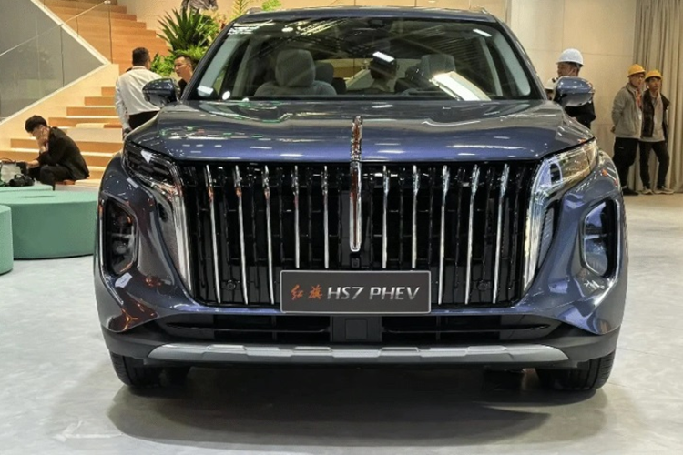 Đầu xe SUV Hongqi HS7 PHEV 2024 bản PHEV gây ấn tượng với lưới tản nhiệt cỡ lớn gồm các thanh kim loại dọc có thiết kế kiểu thác nước và logo cờ đỏ ngay trung tâm, chạy liền mạch lên khu vực nắp capo.