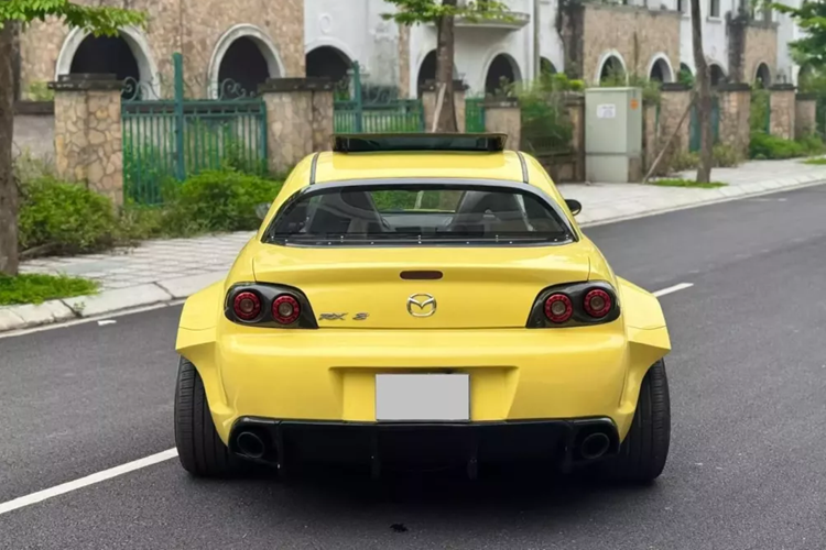 Nhìn từ phía sau sẽ thấy chiếc xe Mazda RX-8 của Qua Vũ như 1 gã khổng lồ trong thân hình tý hon. Nội thất xe còn khá mới, mang tông màu tối, cửa tự sát đã là đặc trưng của dòng xe Mazda RX-8, trong đó, bản lề cửa sau gắn ngược, tạo ra thế mở cửa như xe Rolls-Royce, giúp cho việc ra vào khoang lái của người ngồi hàng ghế sau thoải mái hơn rất nhiều.