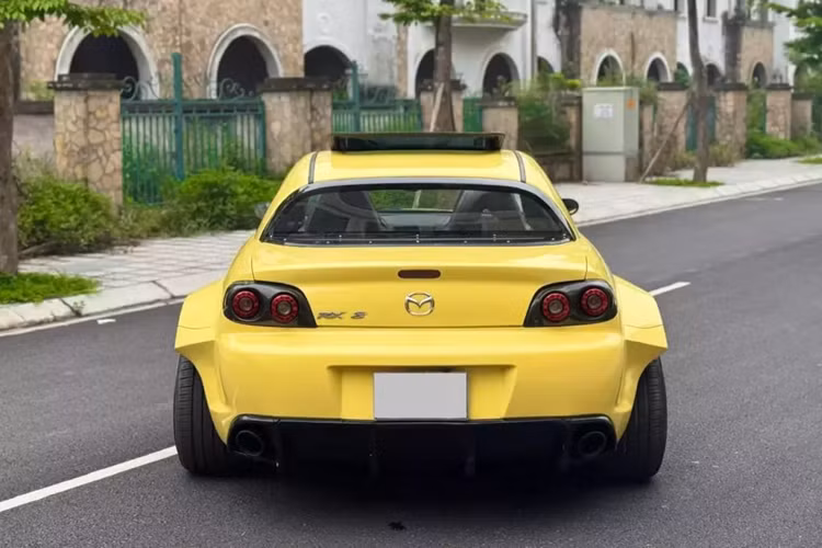 Nhìn từ phía sau sẽ thấy chiếc xe Mazda RX-8 của Qua Vũ như 1 gã khổng lồ trong thân hình tý hon. Nội thất xe còn khá mới, mang tông màu tối, cửa tự sát đã là đặc trưng của dòng xe Mazda RX-8, trong đó, bản lề cửa sau gắn ngược, tạo ra thế mở cửa như xe Rolls-Royce, giúp cho việc ra vào khoang lái của người ngồi hàng ghế sau thoải mái hơn rất nhiều.