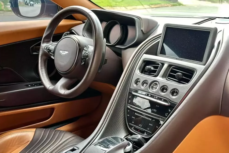 Khi cánh cửa chim 45 độ của xe Aston Martin DB11 V8 được mở ra sẽ khiến khách hàng choáng ngợp trước các vật liệu cao cấp như da đắt tiền, nhôm và cả sợi carbon kèm phối 2 màu nội thất. Bảng điều khiển trung tâm ngoài bọc da còn có thêm sợi carbon nhám.