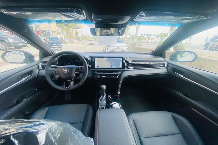 Về nội thất, Toyota Camry 2.0Q sở hữu khoang cabin hiện đại với các tiện ích như: Cụm đồng hồ kỹ thuật số kết hợp với màn hình trung tâm cảm ứng 12,3 inch, hệ thống âm thanh 9 loa JBL, vô lăng chỉnh điện, sạc không dây, cửa sổ trời đơn, hiển thị thông tin lên kính lái HUD…