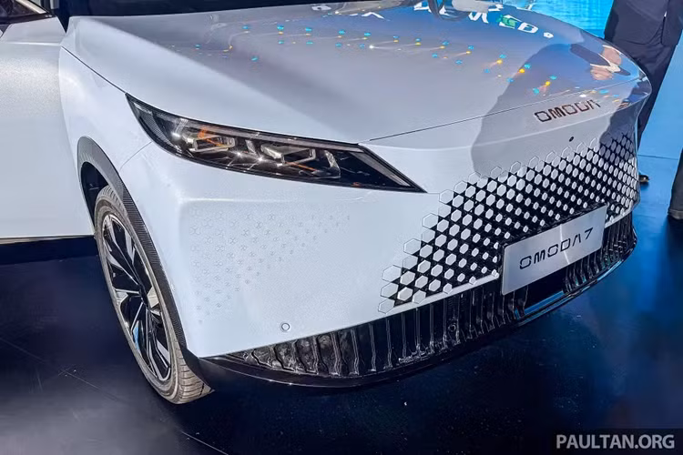 Bên cạnh đó là cụm đèn pha sắc sảo, góc cạnh và hốc gió trung tâm rộng trên cản trước, khá giống mẫu ô tô điện Omoda E5. Ngoài ra, Chery Omoda 7 còn dùng bộ vành hợp kim 20 inch với thiết kế đa chấu, phay xước 2 màu, tay nắm cửa thông thường, đường chân kính hất lên ở cột C và nóc dốc về phía sau.