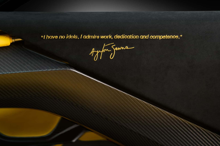 Ngoài ra, khoang nội thất của xe còn có ghế ngồi màu vàng và một câu Quote của Senna cũng như chữ ký của tay đua trên viền cửa.