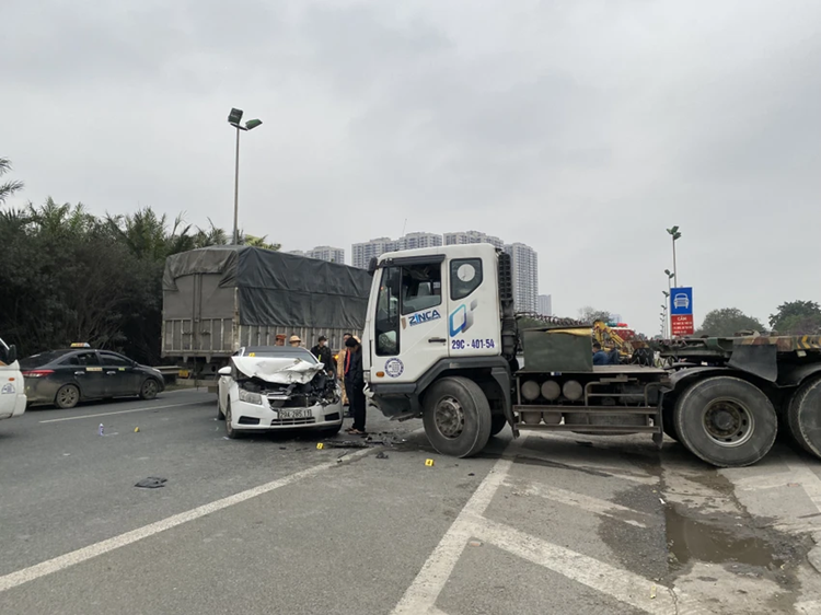 Vụ tai nạn liên hoàn xảy ra khoảng 16h ngày 26/2 giữa xe đầu kéo và hai ô tô con. Khu vực xảy ra tai nạn gần trụ sở Cảnh sát biển Việt Nam, có lối mở từ đường gom vào cao tốc. Sau tai nạn liên hoàn, xe đầu kéo gần như chắn ngang đường gom khiến giao thông ùn tắc. Ảnh: XUÂN NGUYỄN 