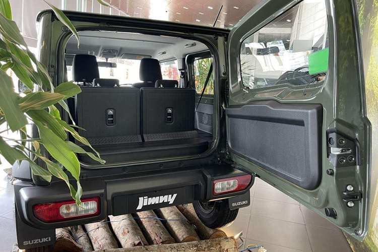 Nội thất Jimny khá đơn giản nếu so với mức giá khoảng 800 triệu đồng. Đồng hồ dạng analog kết hợp màn hình đơn sắc. Màn hình trung tâm kích thước 7 inch dạng nổi là chi tiết hiện đại hơn. Núm chỉnh điều hoà dạng xoay giống trên Swift. Bên trong bố trí 4 chỗ ngồi.