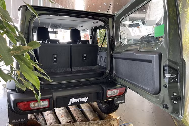 Nội thất Jimny khá đơn giản nếu so với mức giá khoảng 800 triệu đồng. Đồng hồ dạng analog kết hợp màn hình đơn sắc. Màn hình trung tâm kích thước 7 inch dạng nổi là chi tiết hiện đại hơn. Núm chỉnh điều hoà dạng xoay giống trên Swift. Bên trong bố trí 4 chỗ ngồi.