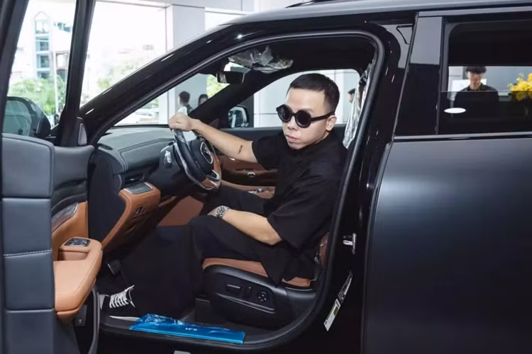 Phong cách đi nhận xe VinFast VF9 của Hoàng Touliver cũng rất ngầu, anh diện đồ đen, đi giày đen và không quên đeo cặp kính màu đen. Điểm sáng trong trang phục này phải kể đến đế giày màu trắng và đồng hồ đắt tiền màu sáng.