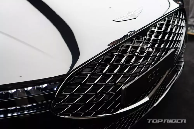 Vành la-zăng của Genesis G90 Black 2024 có đường kính 21 inch với thiết kế 5 chấu và sơn màu xám khá ấn tượng. Bên trong xe, Genesis G90 Black 2024 được trang bị những vật liệu cao cấp như gỗ, ghế bọc da semi-aniline, các nút bấm/núm xoay ốp kim loại và lưới loa bằng nhôm. 