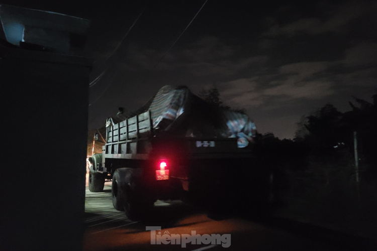 Xe quân đội liên tục chở các thiết bị, mảnh vỡ từ máy bay ra khỏi khu dân cư trong đêm. (Ảnh: Giang Thanh).