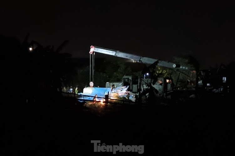 Khu vực phần đuôi máy bay rơi. Ở đây là bãi đất trống, bên cạnh vườn của các hộ dân. Tại hiện trường, xe cẩu, máy cắt cùng các thiết bị khác đã được đưa vào. Hàng chục chiến sĩ, công nhân tiến hành cưa cắt phần đuôi máy bay. (Ảnh: Thanh Trần).
