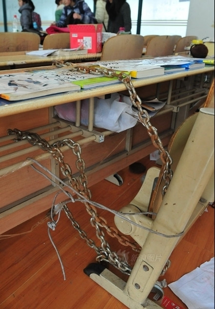 Dùng băng dính để cố định sách vở trên bàn, dùng xích sắt để xích ghế vào bàn vẫn cảm thấy chưa đủ chắc chắn, sinh viên này còn dùng dây thép để buộc ghế vào với bàn.