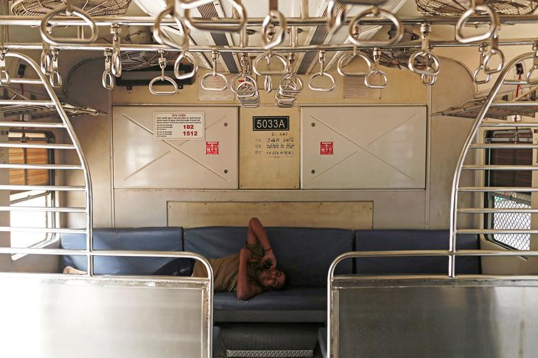 Một nhân viên nằm trong toa tàu trống không sau khi dịch vụ đường sắt ở Mumbai tạm đóng cửa hôm 23/3.