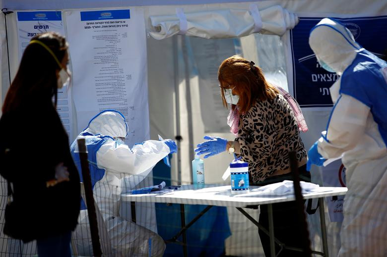 Cử tri đeo khẩu trang và găng tay cẩn thận khi đi bỏ phiếu.