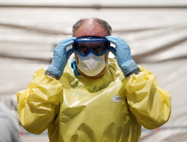 Một nhân viên y tế mặc đồ bảo hộ chuẩn bị đón bệnh nhân tới bệnh viện dã chiến được xây dựng tại trung tâm hội nghị IFEMA ở Madrid, Tây Ban Nha, ngày 21/3.