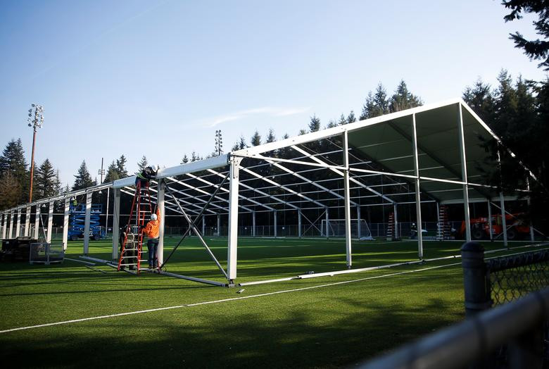 Các công nhân khẩn trương xây dựng một bệnh viện dã chiến 200 giường dành cho những người bệnh hoặc có nguy cơ nhiễm Covid-19, ở Shoreline, Washington, Mỹ, ngày 19/3. Số ca mắc Covid-19 ở Mỹ đang tăng nhanh khiến nước này có nguy cơ trở thành "tâm dịch" mới trên thế giới.