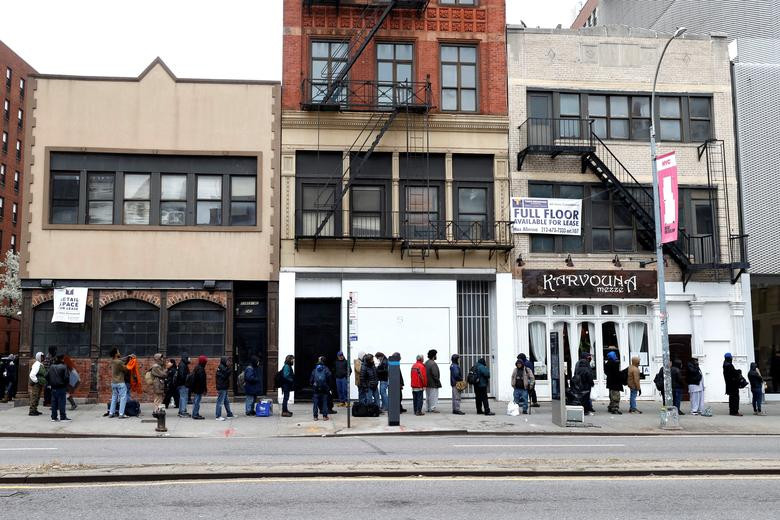 Nhiều người vô gia cư xếp hàng nhận đồ ăn miễn phí ở Manhattan ngày 25/3.
