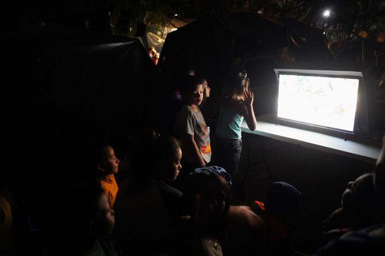 Các em nhỏ tập trung xem phim hoạt hình trong khu trại ngày 22/3.