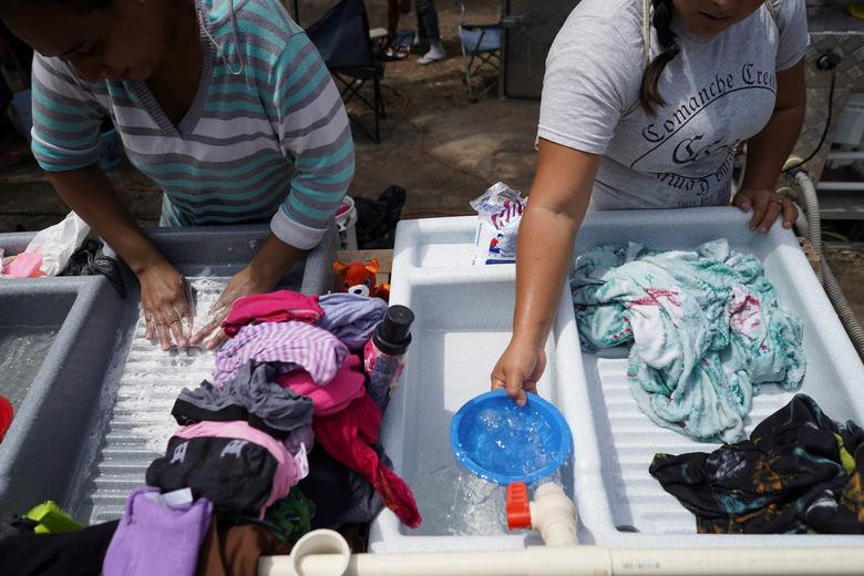 Những người dân di cư giặt quần áo trong khu trại.