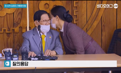 Ngày 3/3, danh tính và vai trò thực sự của người phụ nữ trên đã được hé lộ. Theo truyền thông Hàn, tên người phụ nữ này là Kim Pyung-wha (Pyungwha trong tiếng Hàn có nghĩa là hòa bình), mặc dù chưa biết đó có phải là tên thật hay không. Ảnh chụp màn hình.