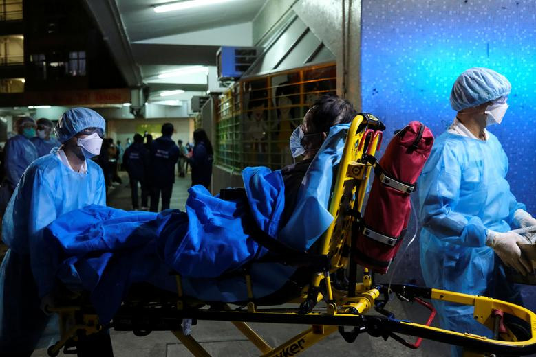 Các y bác sĩ mặc đồ bảo hộ chuyển bệnh nhân lên xe cứu thương trong lúc mọi người sơ tán cư dân khỏi một tòa chung cư tại Fu Heng, Hong Kong (Trung Quốc), hôm 14/3. Mời độc giả xem thêm video: WHO chính thức đặt tên cho virus corona mới là SARS-CoV-2 (Nguồn video: VTC1)