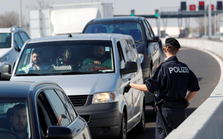 Một cảnh sát Áo ra hiệu cho tài xế ô tô gần Nickelsdorf, Áo, ngày 18/3 trong bối cảnh biên giới Áo-Hungary bị đóng cửa vì lo dịch bệnh lan rộng.