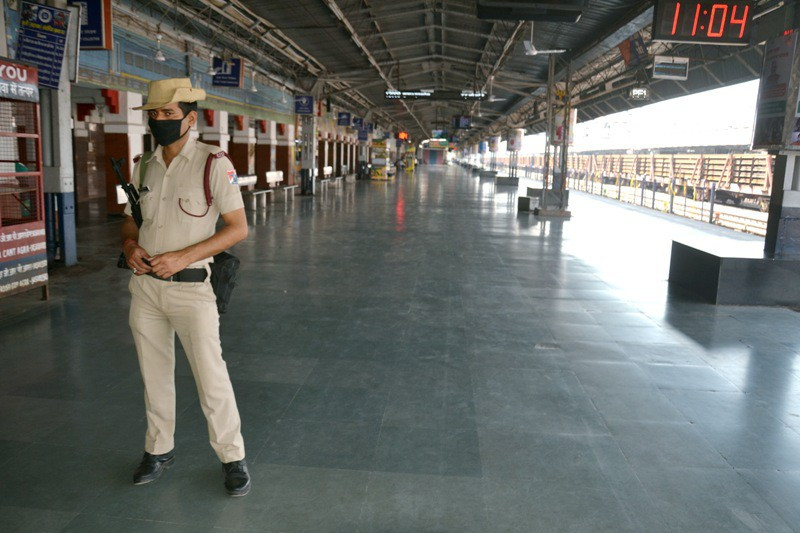 Cảnh sát đứng canh gác bên ngoài ga tàu hỏa Agra Cantt, tại thành phố Agra, bang Uttar Pradesh. Tất cả các chuyến tàu chở khách trên toàn Ấn Độ được lệnh dừng hoạt động từ hôm nay tới ngày 31/3. Dịch vụ đường sắt đô thị cũng gần như bị đình chỉ hoàn toàn. (Ảnh: ANI)