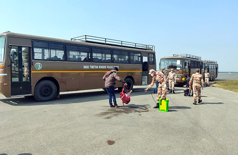 Cảnh sát phun thuốc khử trùng hành lý của các công dân vừa từ Rome trở về nước. Chính quyền lo ngại virus SARS-CoV-2 sẽ lây lan nhanh trong cộng đồng theo sau những trường hợp về nước trong vài tuần qua. (Ảnh: ANI)