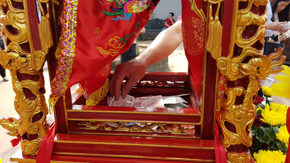 Nhiều người đặt tiền lẻ trong kiệu ấn.