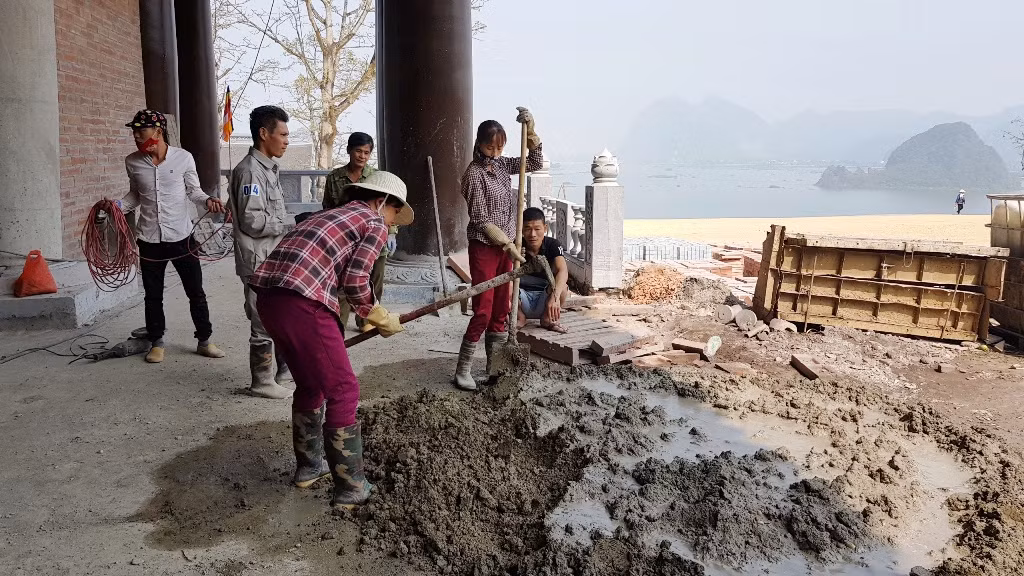 Các công nhân thi công bên ngoài điện Pháp Chủ.