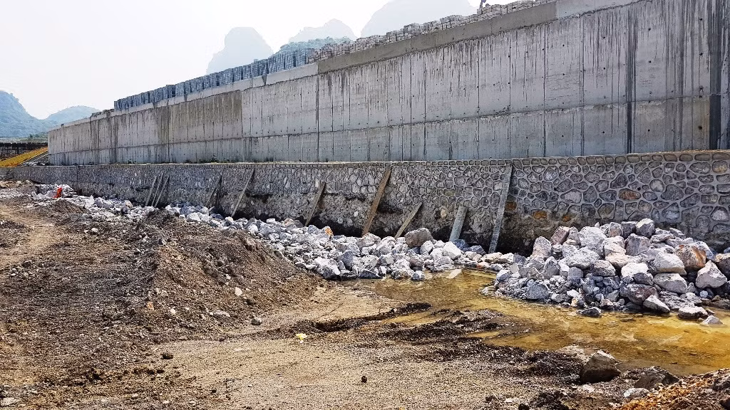 Tường dưới chân điện Quan Âm đang bề bộn.