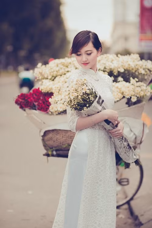 Những thiếu nữ Hà thành cũng tranh thủ dịp này, diện áo dài, váy vóc, đứng bên cúc họa mi chụp ảnh kỷ niệm. Sự e ấp, dịu dàng của các cô gái kết hợp với sự tinh khôi của cúc họa mi tạo nên vẻ đẹp say lòng người. Ảnh: Sự xuất hiện của thiếu nữ xinh đẹp cùng chiếc xe chở đầy họa mi trắng khiến phố phường Hà Nội trở nên bình yên hơn.