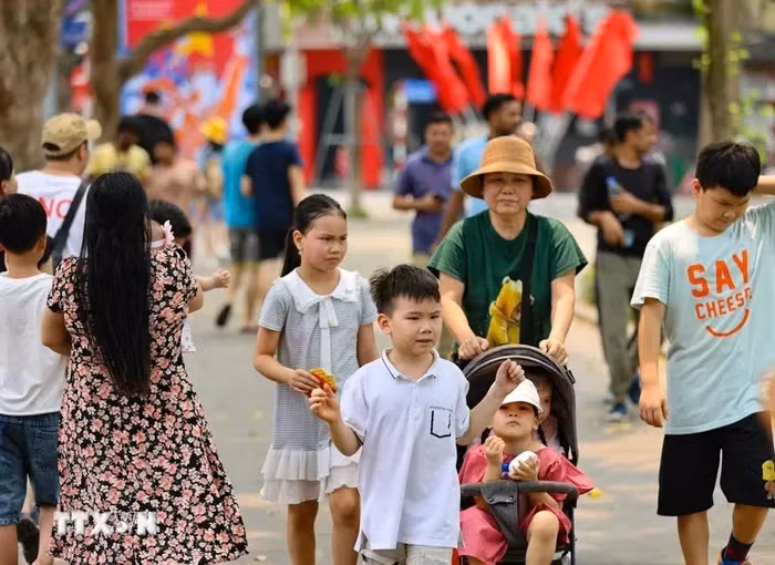 Dù nắng nóng nhưng người dân và du khách vẫn dạo bước, ngắm cảnh bên hồ. (Ảnh: Thanh Tùng/TTXVN)