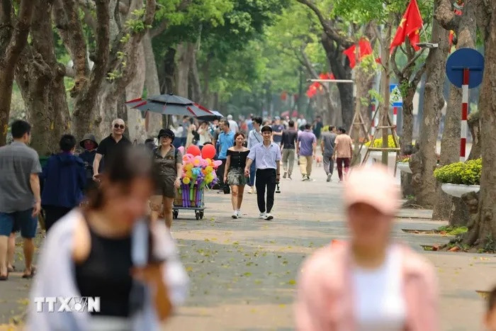 Dù nắng nóng nhưng người dân và du khách vẫn dạo bước, ngắm cảnh bên hồ. (Ảnh: Thanh Tùng/TTXVN)