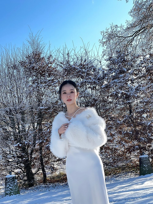Hình ảnh Midu mặc chiếc váy trắng, áo khoác lông khoe nhan sắc gây mê giữa tuyết trắng xóa.