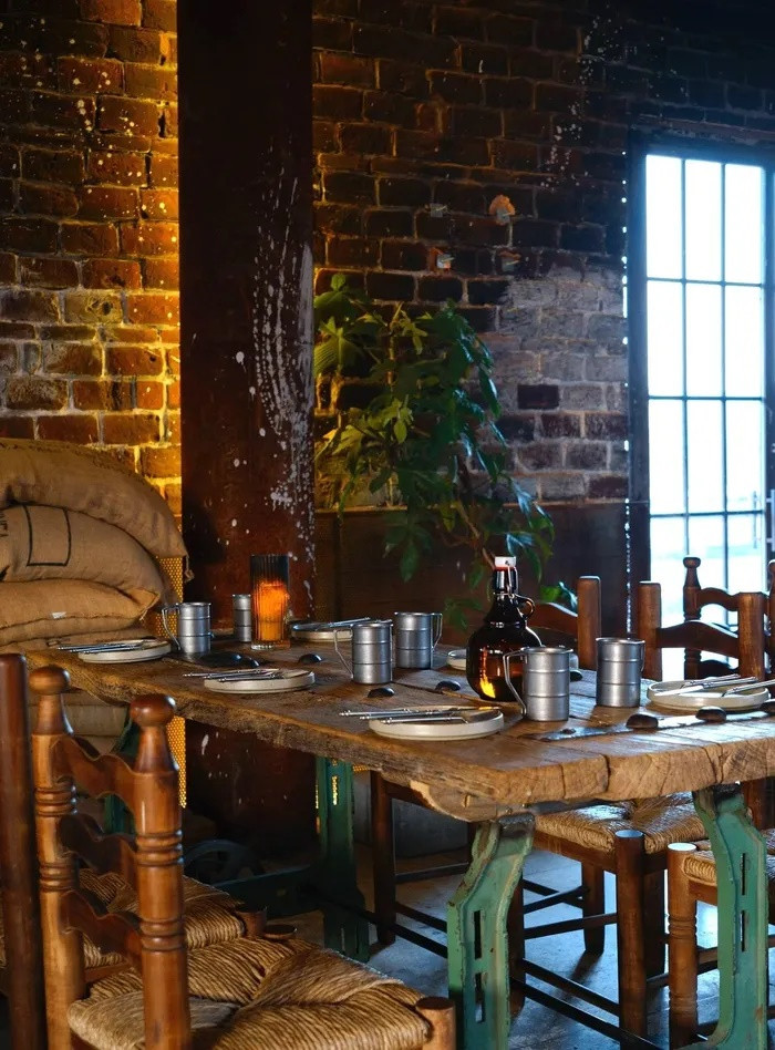 Là nhà hàng BBQ với thiết kế khác biệt, đặc trưng phong cách hầm mỏ và mang "hơi thở" của nhà máy công nghiệp cũ, Trạm Hầm (quận 3) nép mình sau cánh cửa độc đáo. Với lối thiết kế đậm dấu ấn industrial, những mảng tường gạch thô, ánh đèn vàng, khu vực bếp mở độc đáo... tất cả tạo nên trải nghiệm ẩm thực thú vị. Bạn có thể thưởng thức một số món signature tại tiệm như gà nướng hạt mắc khén, ba chỉ heo nướng lá mắc mật hay bò nướng muối kiến. Ảnh: Tramhamgrillandchill.