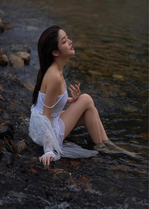 Cô nàng diện váy hai dây trắng mỏng manh.