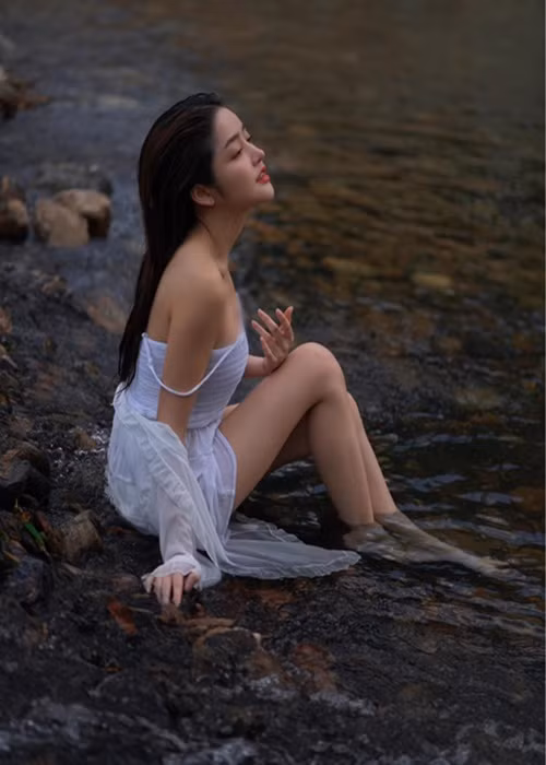 Cô nàng diện váy hai dây trắng mỏng manh.