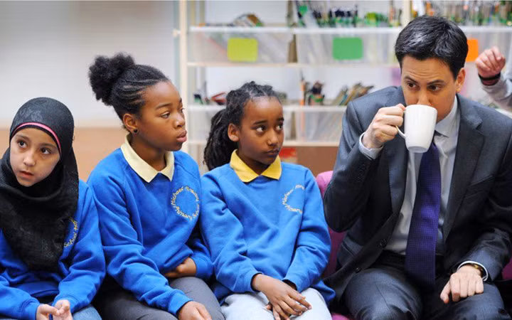 Ông Ed Miliband đường đường là lãnh đạo Công đảng Anh khi đó nhưng trong bức ảnh này vị chính trị gia trông khép nép dưới ánh mắt dò xét của 2 nữ sinh.