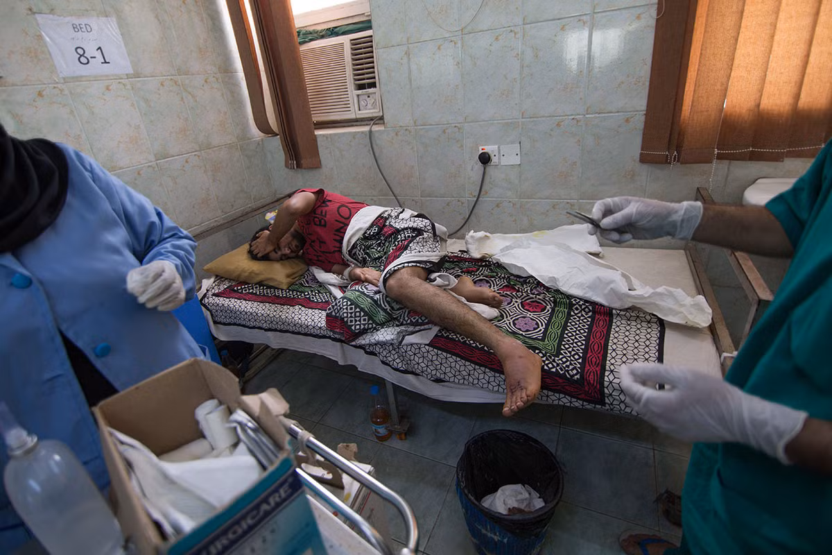 Một thanh niên bị trúng đạn ở chân được điều trị trong bệnh viện ở Yemen.