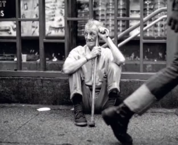 Một cụ già vô gia cư ngồi bên đường ở khu Manhattan năm 1981.