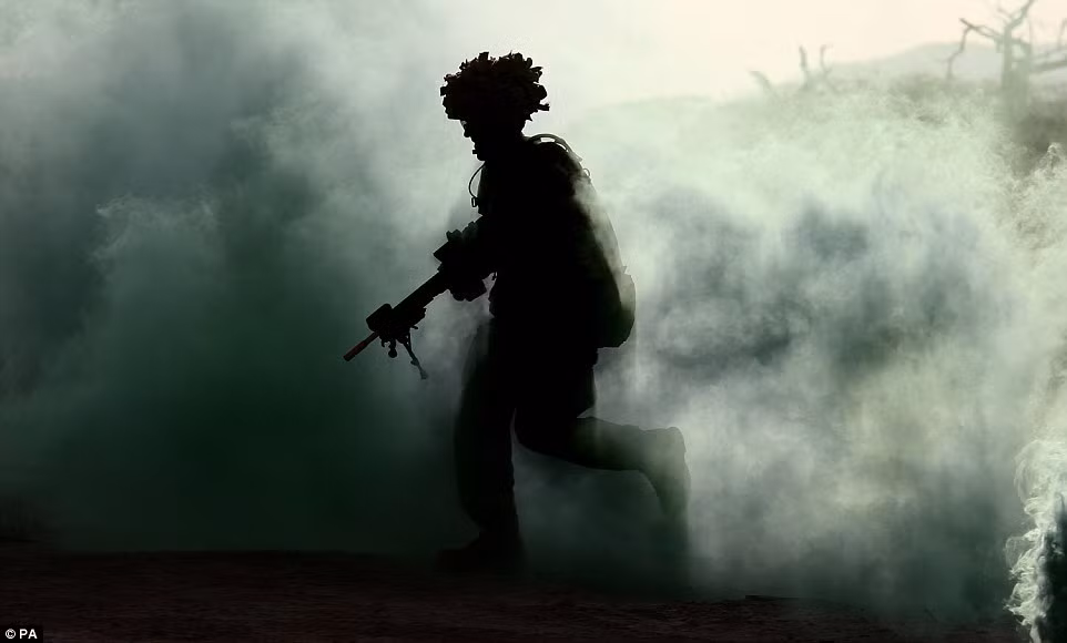 Một thành viên của 2 SCOTS chạy qua cánh đồng mù mịt khói bụi trong cuộc tập luyện Cơn bão Askari kéo dài 6 tuần.