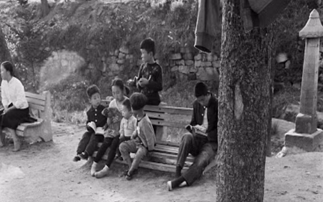 Một đám trẻ nhỏ ngồi nghe chị đọc truyện tại một địa điểm ở Seoul. Ảnh: Vintag