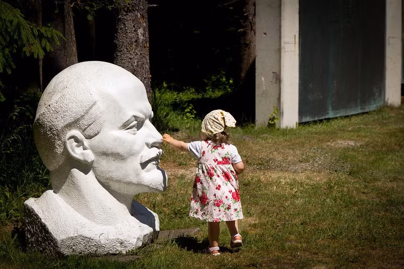 Bé gái thích thú khi đi qua bức tượng Lenin ở Cộng hòa Litva. (Nguồn ảnh: English Russia)