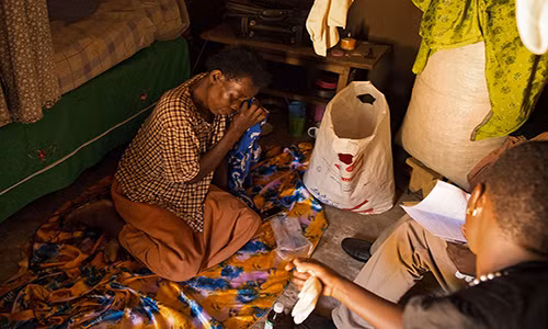 Monica Nakayima ngồi khóc trong nhà của cô ở Jinja, Uganda. Được biết, Monica có triệu chứng bị ung thư buồng trứng.