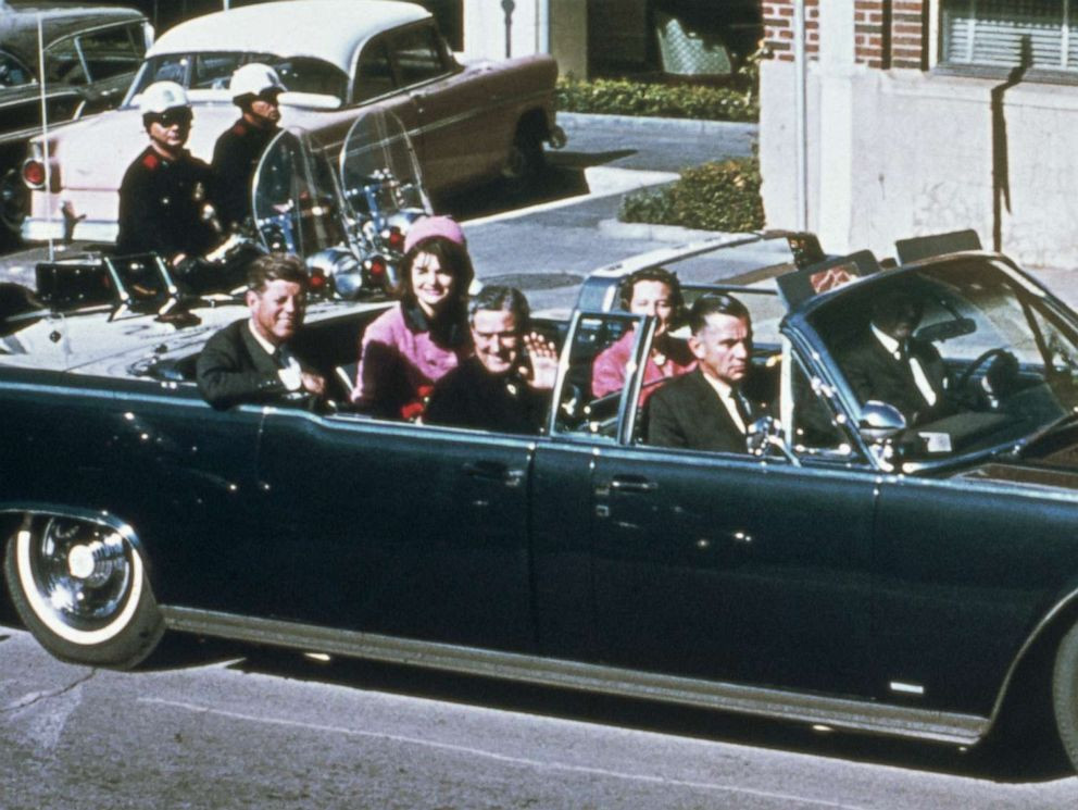 Trong khi đó, Thống đốc bang Texas John Conally và phu nhân ngồi hai ghế phụ phía trước. Hung thủ Lee Harvey Oswald đã dùng khẩu súng trường Mannlicher-Carcano, cỡ nòng 6,5 ly do Italy sản xuất, để bắn Tổng thống Kennedy từ tầng 6 của kho sách tại tòa nhà gần đó.