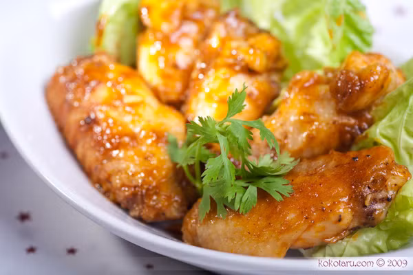 Cuối cùng đun nóng hai thìa nhỏ dầu ăn, phi tỏi thơm, cho sả, ớt bột, tôm khô, bơ đậu phộng vào đảo đều, thêm vào một ít nước lọc và một thìa canh nước mắm, một thìa canh đường, nửa thìa nhỏ muối, đun sôi lửa lớn đến khi hỗn hợp hơi đặc lại, nêm gia vị vừa miệng. Cho cánh gà vào đảo đều đến khi hỗn hợp nước sốt bám đều cánh gà, nhấc nồi ra khỏi bếp, gắp ra đĩa dùng nóng với dưa leo hoặc cơm trắng.